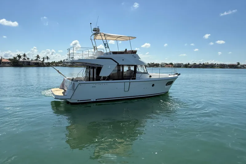  Yacht Photos Pics 2021 Beneteau Swift Trawler 35 cruising on calm waters under a clear blue sky.