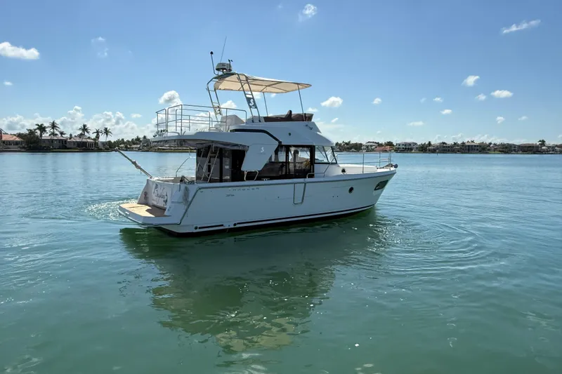  Yacht Photos Pics 2021 Beneteau Swift Trawler 35 cruising on calm waters under a clear blue sky.