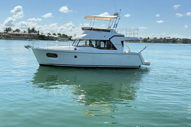  Yacht Photos Pics 2021 Beneteau Swift Trawler 35 cruising on calm waters under a clear sky.