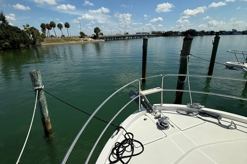  Yacht Photos Pics Bow of 2021 Beneteau Swift Trawler 35 docked in serene waters under blue sky.