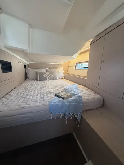 Archimedes Yacht Photos Pics Cozy cabin interior of 2022 Beneteau Oceanis 46.1 yacht with bed and storage.