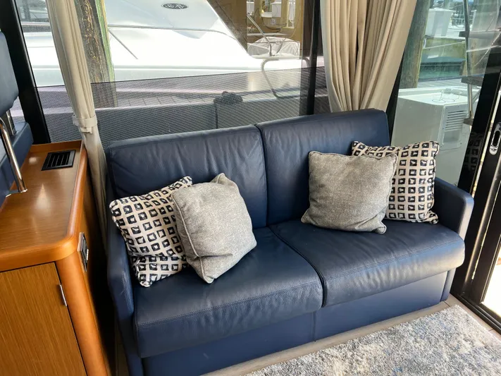  Yacht Photos Pics Interior of 2021 Beneteau Swift Trawler 35 with blue leather sofa and decorative pillows.
