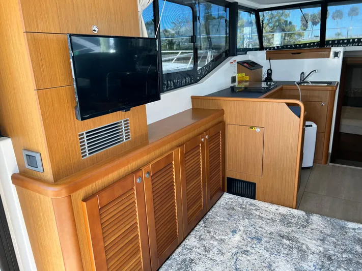  Yacht Photos Pics Interior of 2021 Beneteau Swift Trawler 35 with TV, wooden cabinets, and kitchenette.