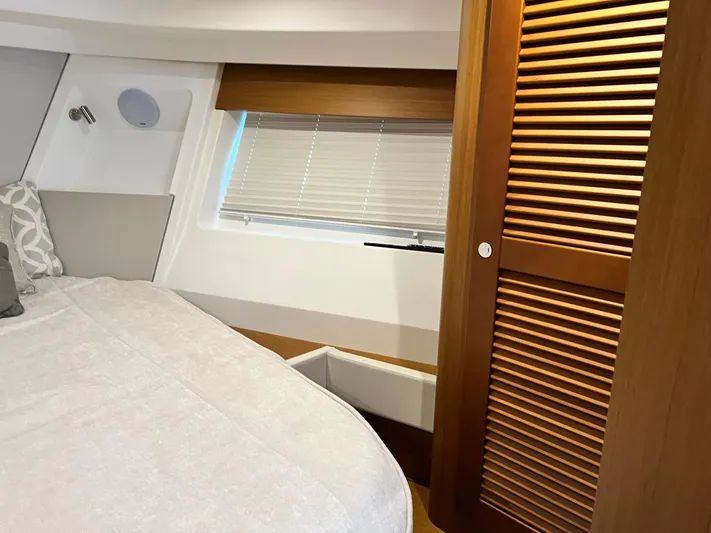  Yacht Photos Pics 2021 Beneteau Swift Trawler 35 bedroom with window, bed, and wooden closet.