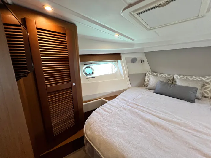  Yacht Photos Pics 2021 Beneteau Swift Trawler 35 bedroom with cozy bed and wooden wardrobe.