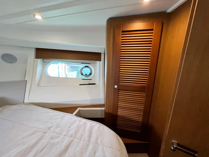  Yacht Photos Pics Interior cabin of 2021 Beneteau Swift Trawler 35 with wooden closet and porthole window.