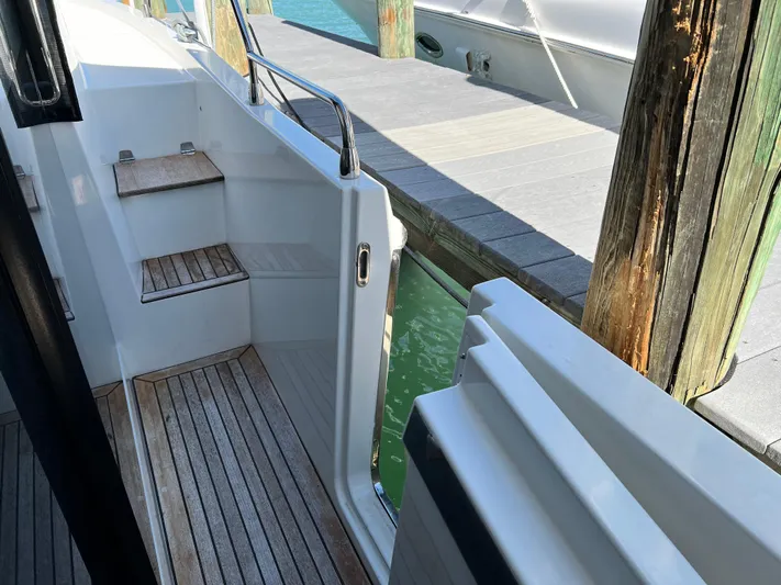  Yacht Photos Pics 2021 Beneteau Swift Trawler 35 docked, showing entry steps and wooden deck.