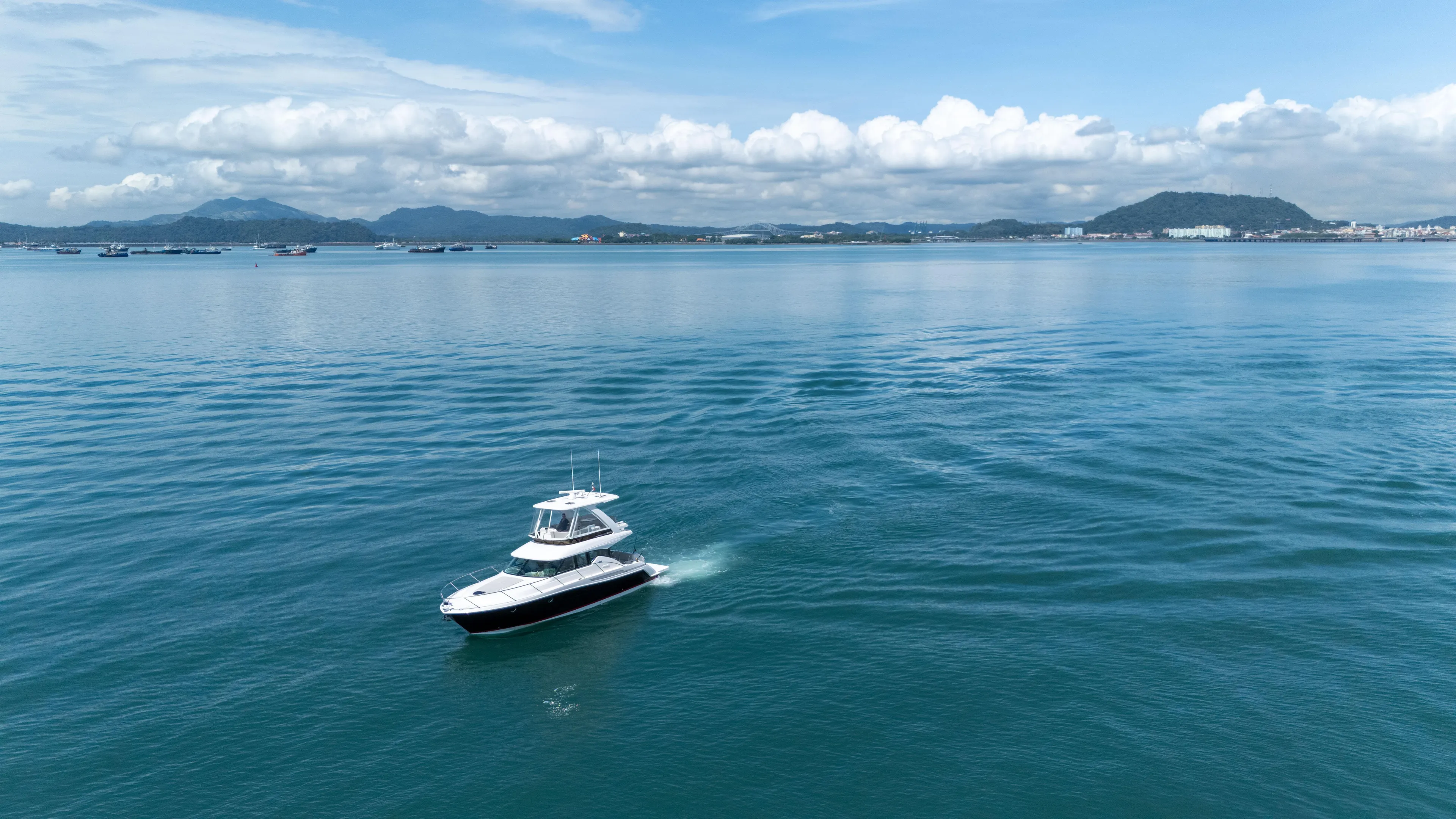  Yacht Photos Pics 2019 Tiara Yachts F44 Flybridge cruising on calm blue waters under a clear sky.