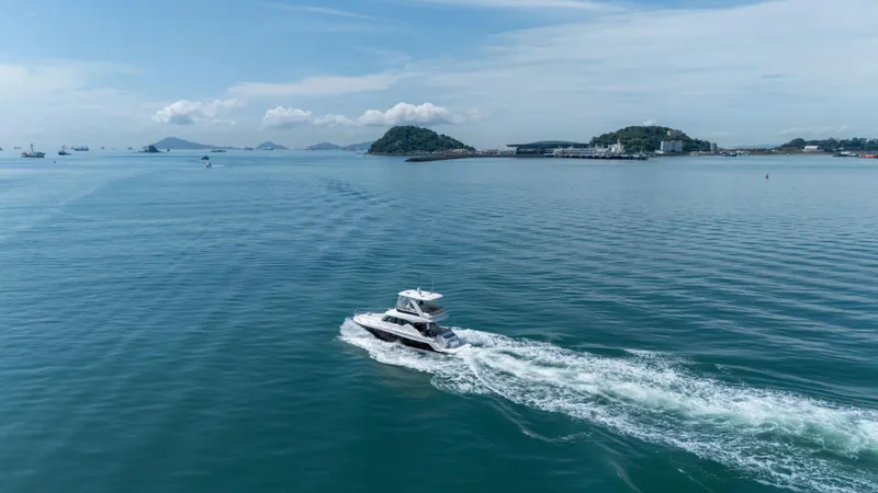  Yacht Photos Pics 2019 Tiara Yachts F44 Flybridge cruising on open sea with scenic island backdrop.