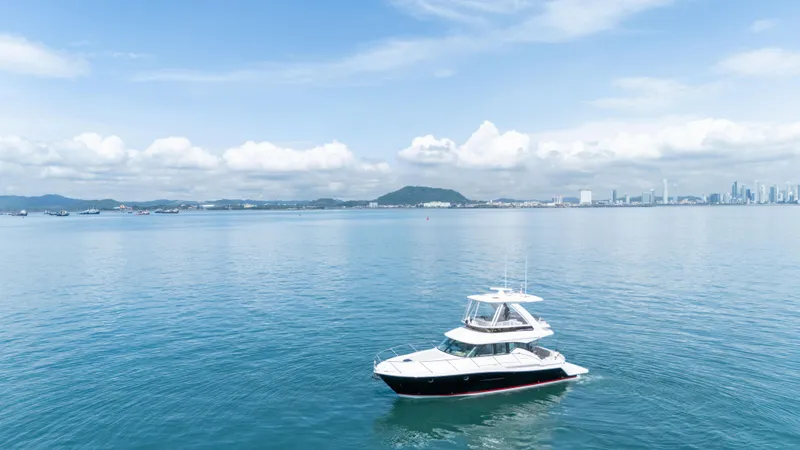  Yacht Photos Pics 2019 Tiara Yachts F44 Flybridge on calm ocean with city skyline in background.