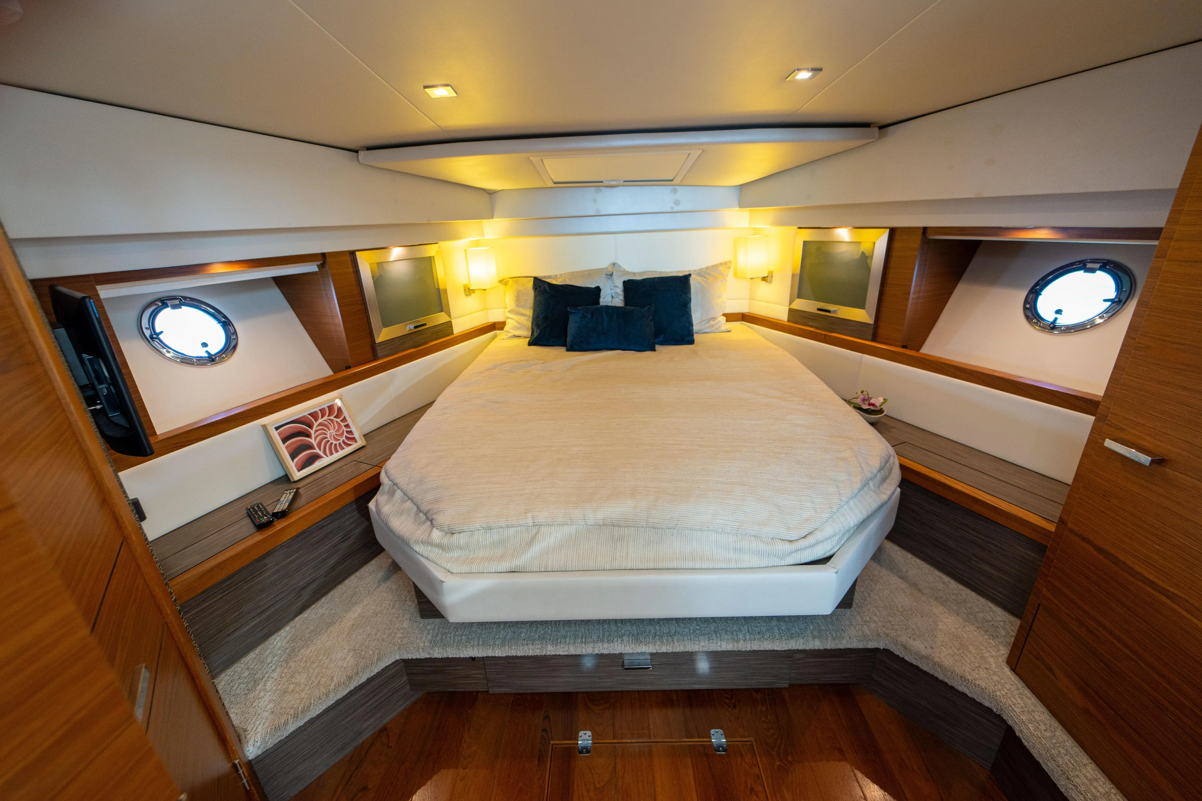  Yacht Photos Pics Luxurious bedroom interior of 2019 Tiara Yachts F44 Flybridge with cozy bedding and elegant lighting.