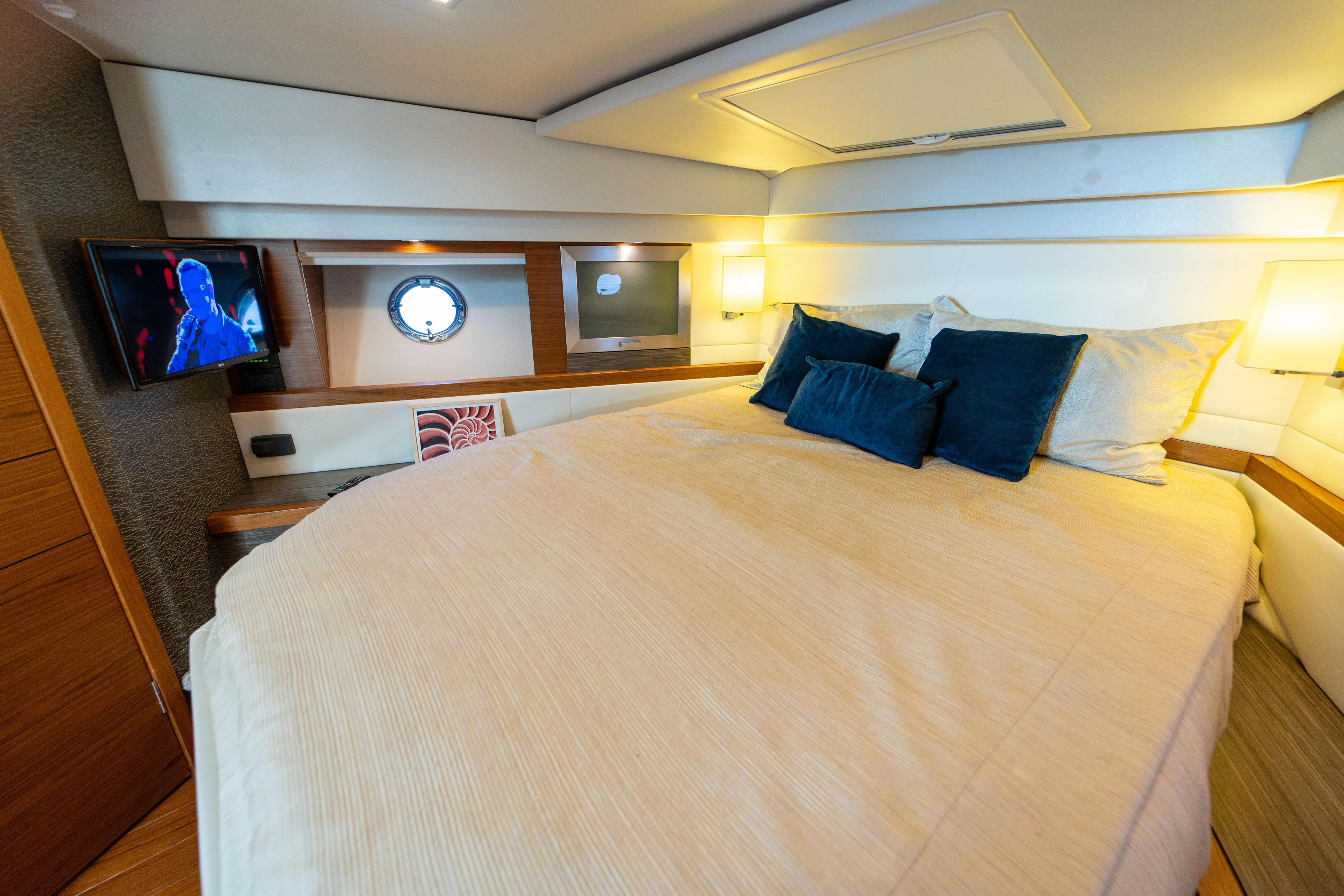  Yacht Photos Pics Luxurious bedroom interior of 2019 Tiara Yachts F44 Flybridge with cozy bedding and ambient lighting.