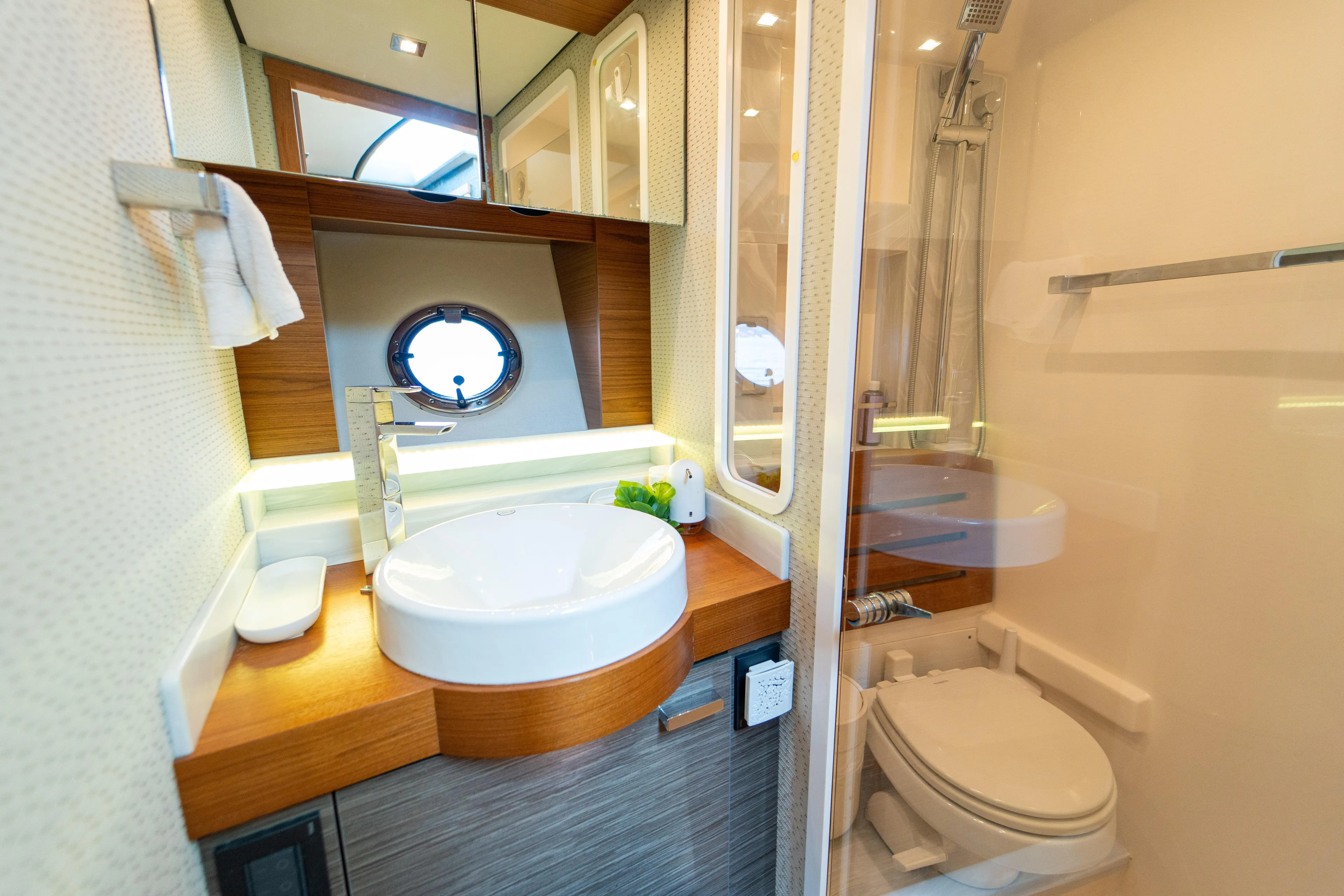  Yacht Photos Pics Luxurious bathroom in 2019 Tiara Yachts F44 Flybridge with modern fixtures and porthole window.