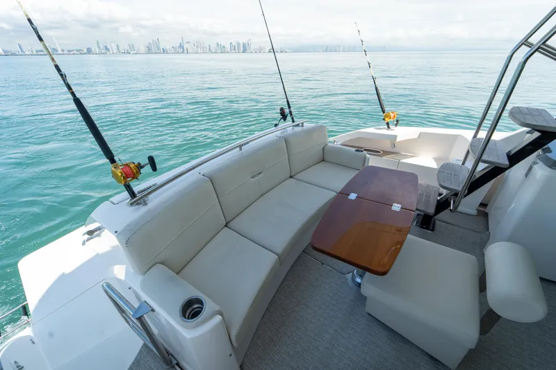  Yacht Photos Pics 2019 Tiara Yachts F44 Flybridge with fishing rods, ocean view, and city skyline in background.