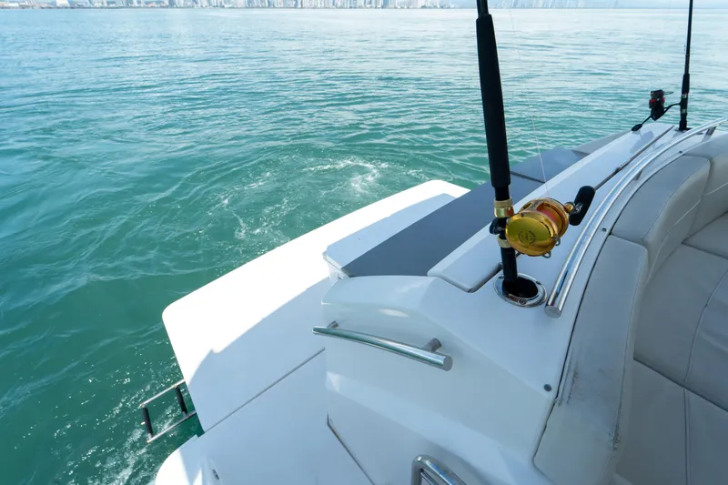  Yacht Photos Pics 2019 Tiara Yachts F44 Flybridge on calm water, featuring fishing rod holders.