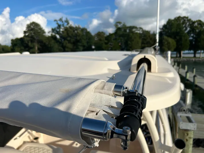 Yacht Photos Pics 2023 Grady-White Freedom 275 boat detail with canopy and railing, docked by trees.