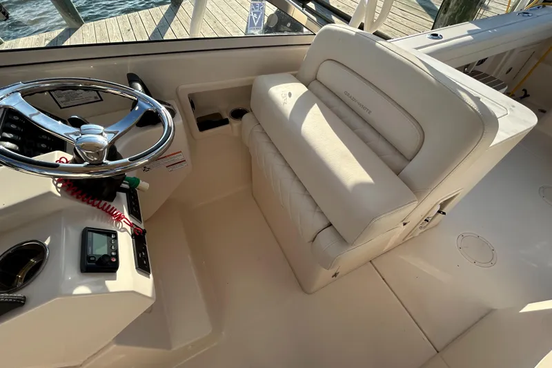  Yacht Photos Pics 2023 Grady-White Freedom 275 boat interior with steering wheel and cushioned seating.