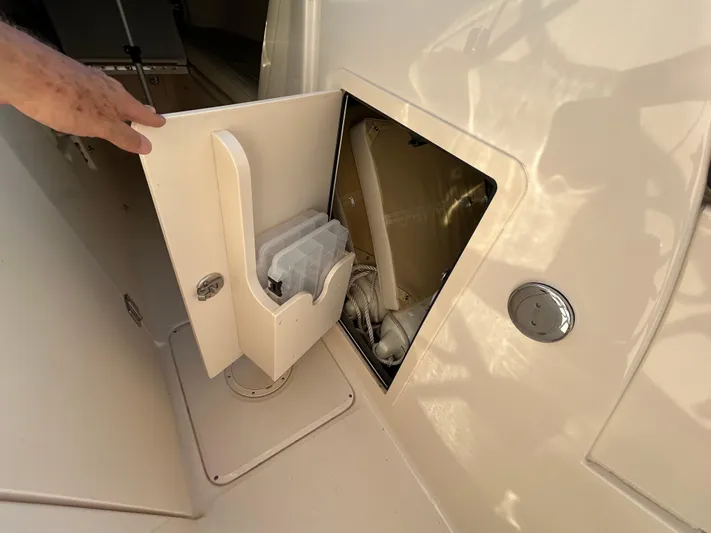  Yacht Photos Pics 2023 Grady-White Freedom 275 boat storage compartment with open door and visible equipment.