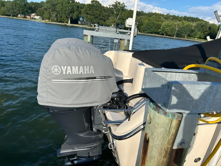  Yacht Photos Pics 2023 Grady-White Freedom 275 with Yamaha engine at dockside, surrounded by water and trees.