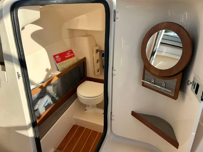  Yacht Photos Pics 2023 Grady-White Freedom 275 boat interior with toilet and mirror.