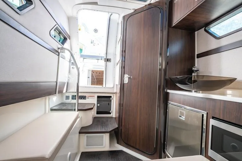  Yacht Photos Pics Interior of 2025 Edgewater 370CC boat with modern wood finishes and compact amenities.