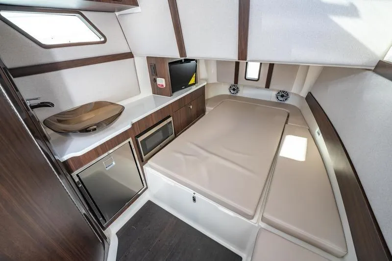  Yacht Photos Pics Luxurious interior of 2025 Edgewater 370CC boat with kitchenette and sleeping area.
