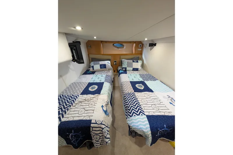  Yacht Photos Pics Interior of 2009 Four Winns V458 yacht with twin beds and nautical-themed bedding.