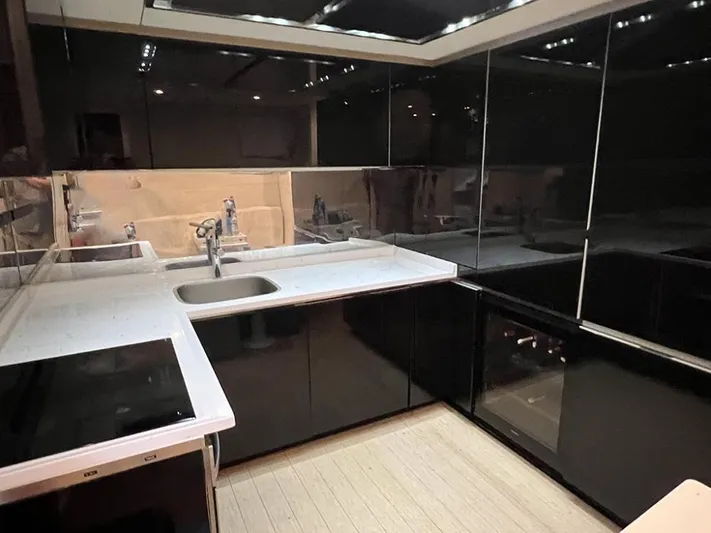  Yacht Photos Pics Modern kitchen with sleek black cabinets and white countertops on a 2012 Pershing 92 yacht.