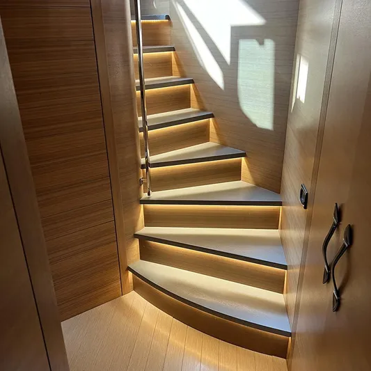  Yacht Photos Pics Curved wooden staircase with ambient lighting on a 2012 Pershing 92 yacht.