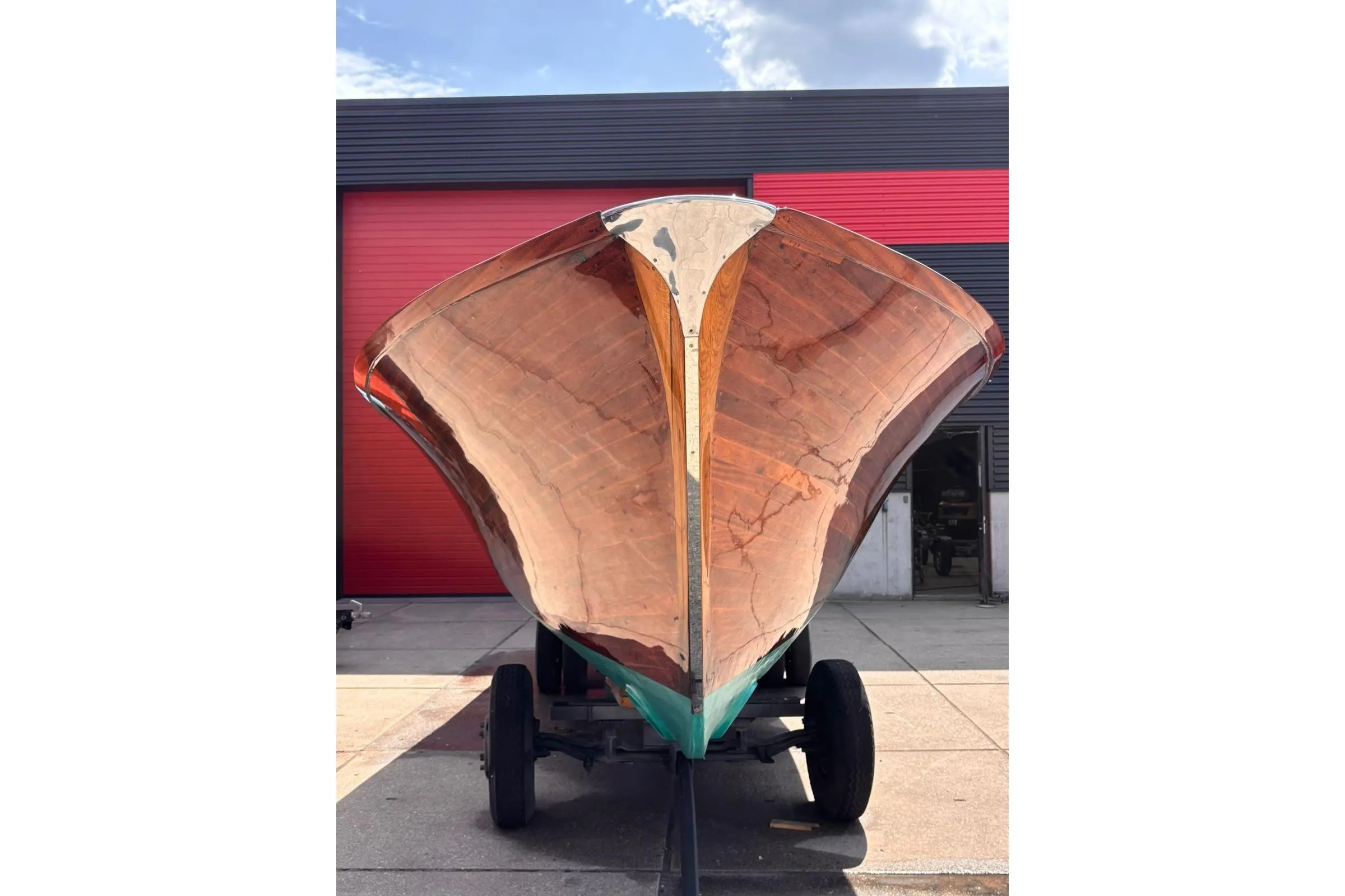 1953 Barca Di Legno Italiana 30 boat with polished wooden hull on trailer.
