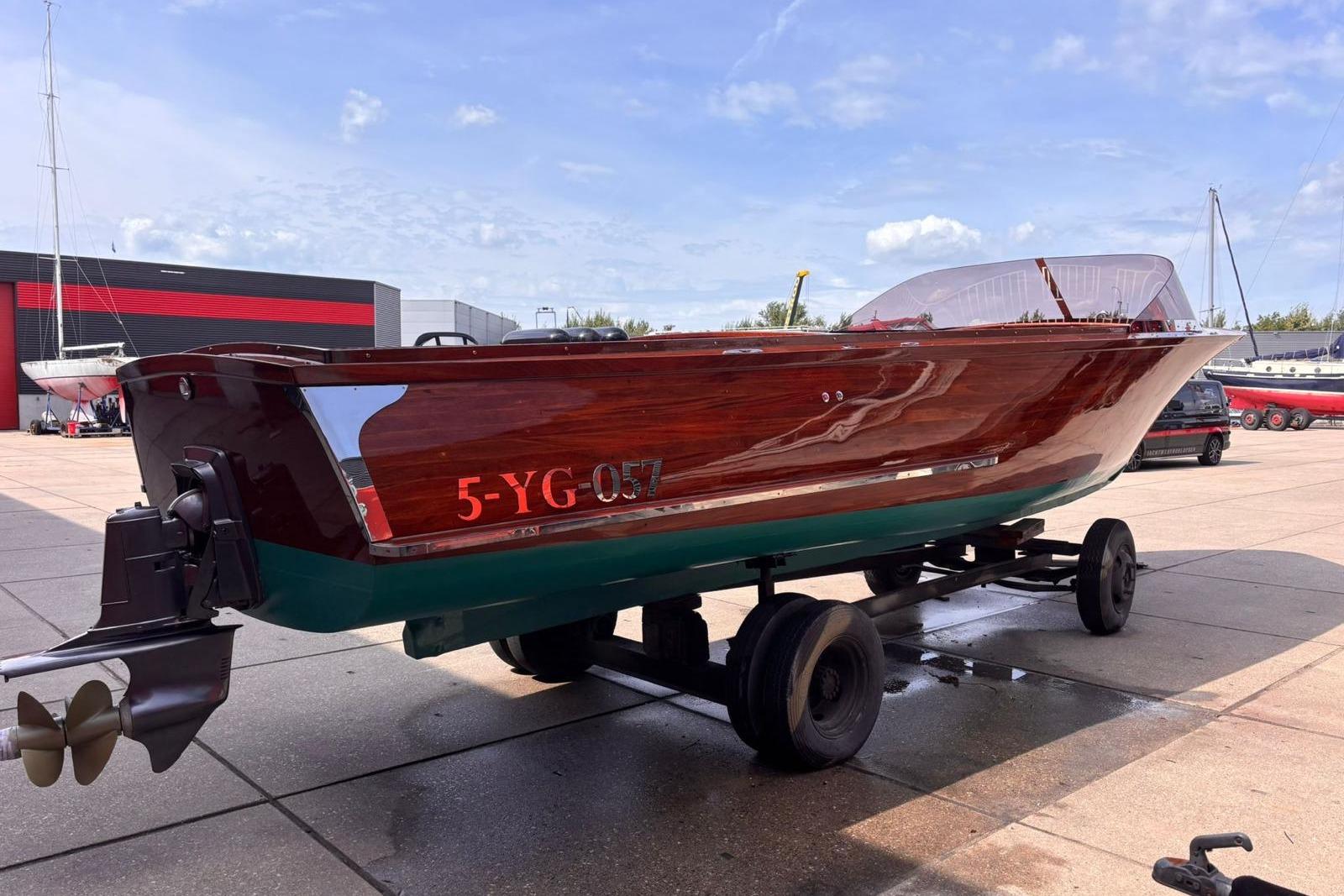Vintage 1953 Barca Di Legno Italiana 30 boat on trailer, showcasing polished wooden finish.