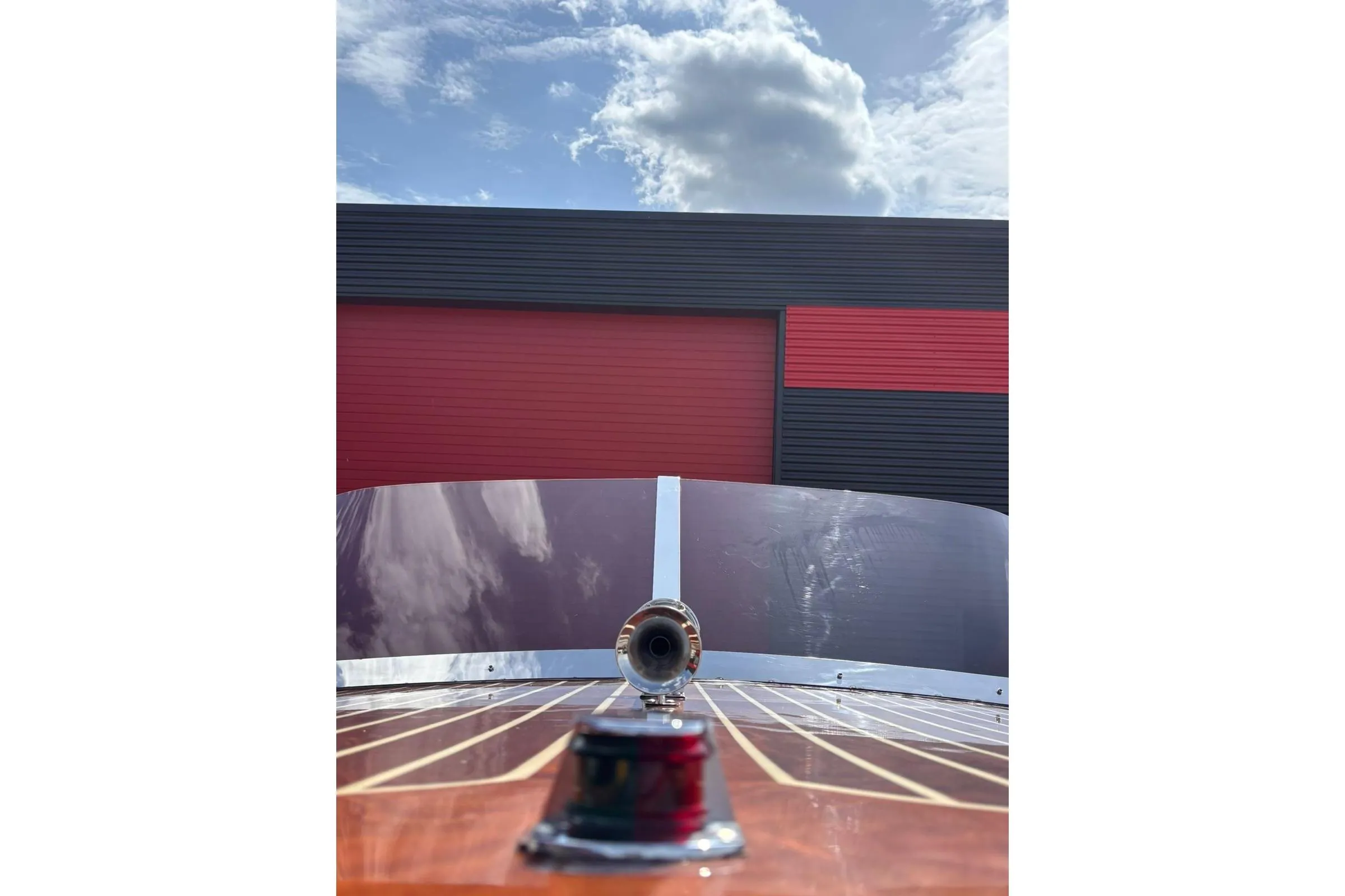 1953 Barca Di Legno Italiana 30 boat with wooden deck and windshield, under a cloudy sky.