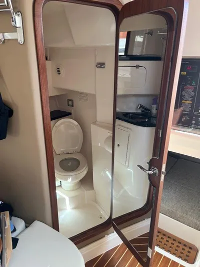  Yacht Photos Pics 2020 Grady-White Express 330 boat bathroom interior with wooden door and modern amenities.