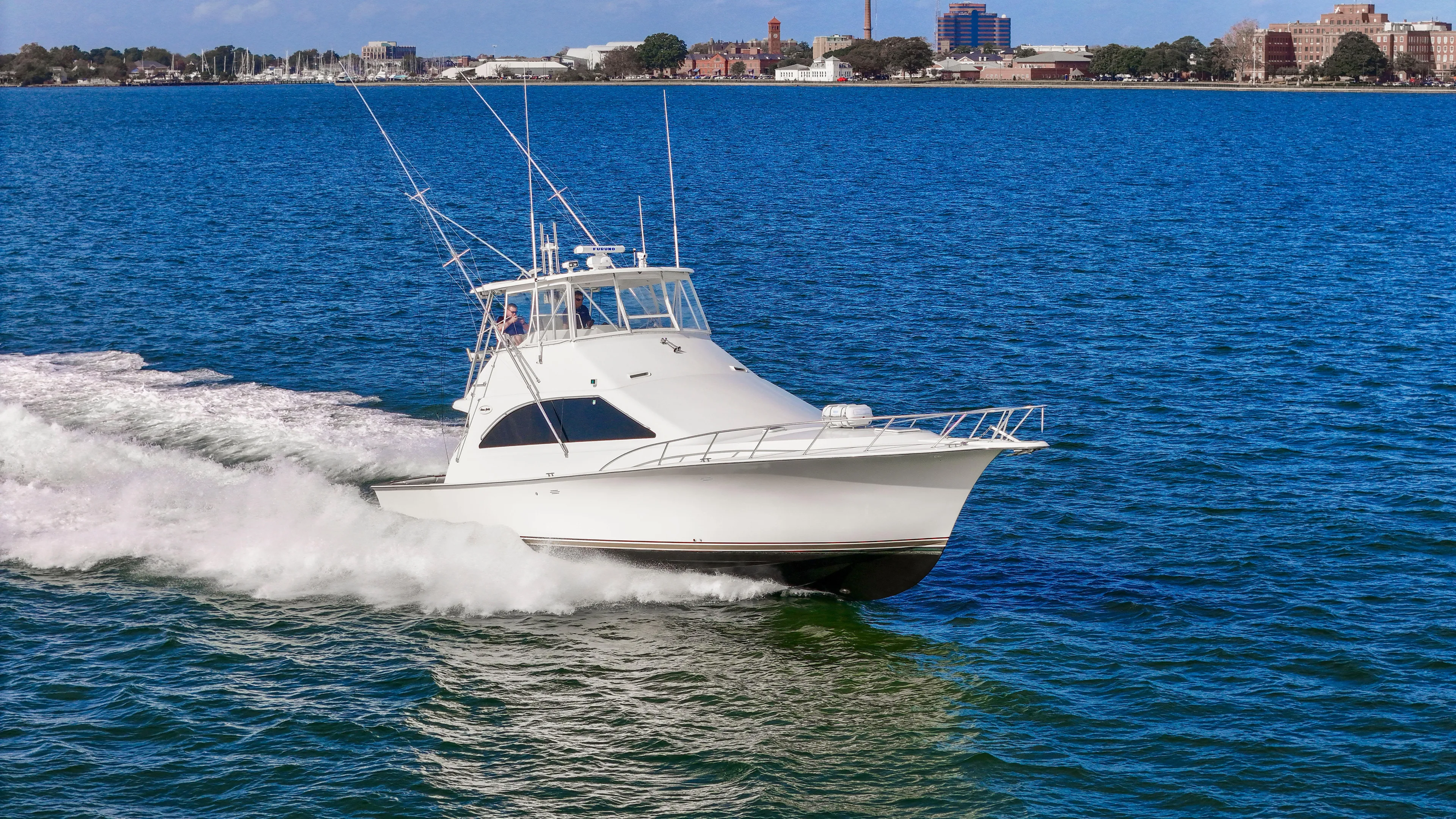 Event Horizon Yacht Photos Pics Ocean Yachts 48 Super Sport 2000 cruising on blue water near city skyline.