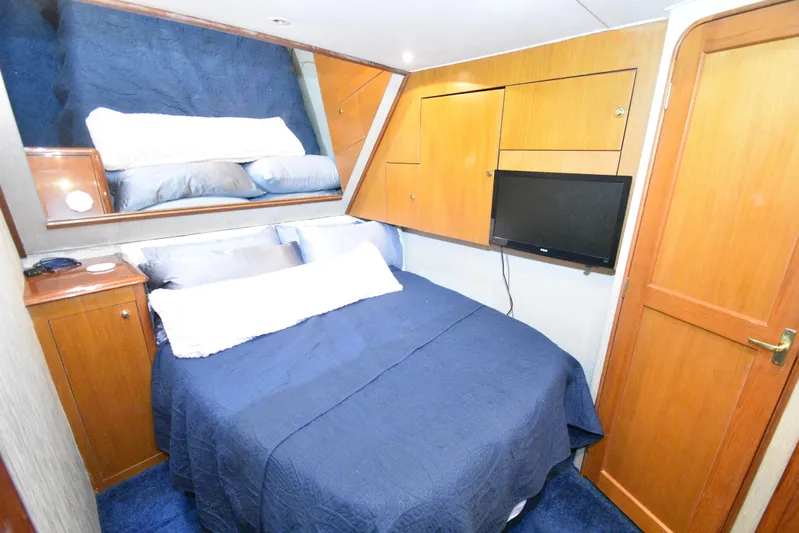 Event Horizon Yacht Photos Pics Cozy cabin interior of 2000 Ocean Yachts 48 Super Sport with bed and TV.
