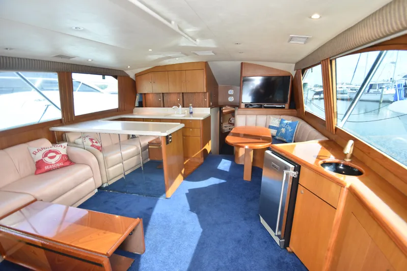 Event Horizon Yacht Photos Pics Luxurious interior of 2000 Ocean Yachts 48 Super Sport with seating, kitchenette, and large windows.