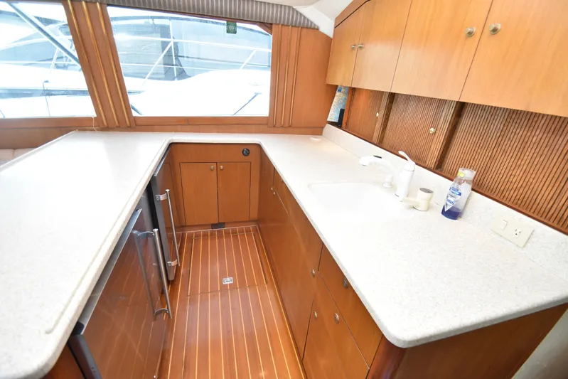 Event Horizon Yacht Photos Pics Luxurious kitchen interior of 2000 Ocean Yachts 48 Super Sport with wooden cabinetry and countertops.