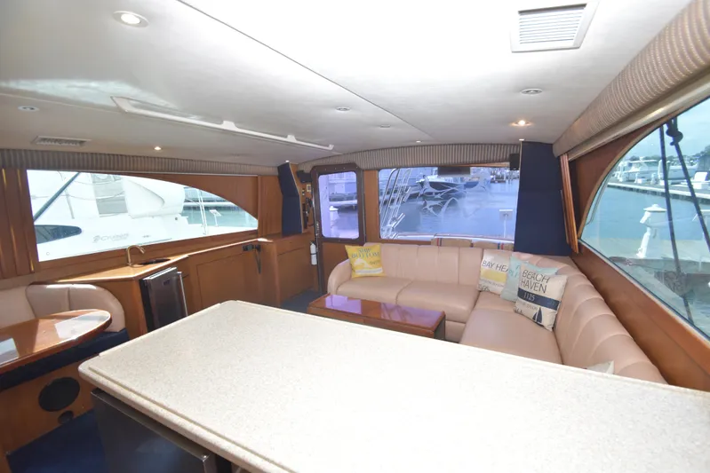 Event Horizon Yacht Photos Pics Luxurious interior of 2000 Ocean Yachts 48 Super Sport with plush seating and marina view.