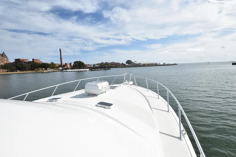 Event Horizon Yacht Photos Pics Bow view of 2000 Ocean Yachts 48 Super Sport on calm waters under a cloudy sky.