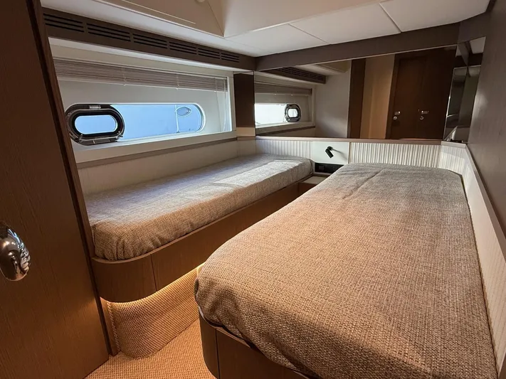  Yacht Photos Pics Interior of 2023 Azimut Magellano 66 yacht with twin beds and porthole window.