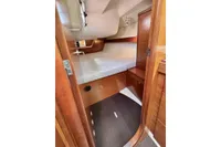 Interior cabin of 2009 Dufour 45E Performance yacht with wooden finish and cozy bed.