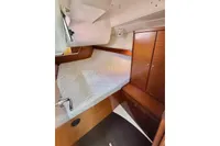 Cozy cabin interior of 2009 Dufour 45E Performance yacht with wooden cabinetry and bed.