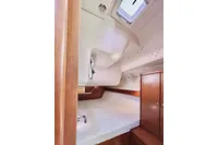 Interior cabin of 2009 Dufour 45E Performance yacht with wooden cabinetry and bedding.