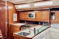 Interior of 2009 Dufour 45E Performance yacht kitchen with wood cabinetry and modern appliances.