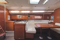Interior of 2009 Dufour 45E Performance yacht with wooden cabinetry and white seating.