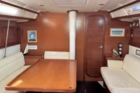 Interior of 2009 Dufour 45E Performance yacht with wooden furnishings and white seating.