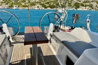 Cockpit of 2009 Dufour 45E Performance yacht with dual steering wheels, anchored in clear blue waters.