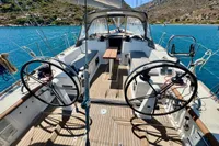 Cockpit of 2009 Dufour 45E Performance sailboat with dual steering wheels, docked in scenic bay.