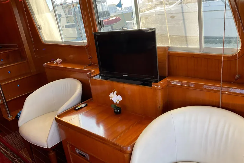 Mariposa Yacht Photos Pics Luxurious Integrity 45 yacht interior with TV, white chairs, and wooden furnishings, 2012 model.