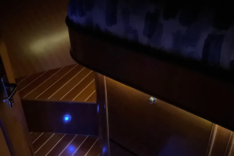 Mariposa Yacht Photos Pics Dimly lit interior of 2012 Integrity 45 yacht with wooden steps and blue lights.